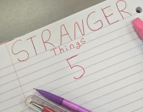 The words Stranger Things 5 written on notebook paper in a red gel pen.